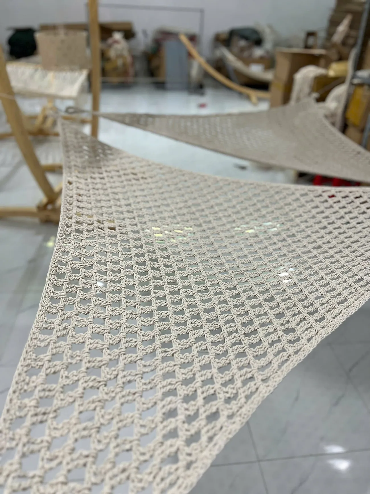 Voile d'ombrage en macramé de coton écru tendue en extérieur